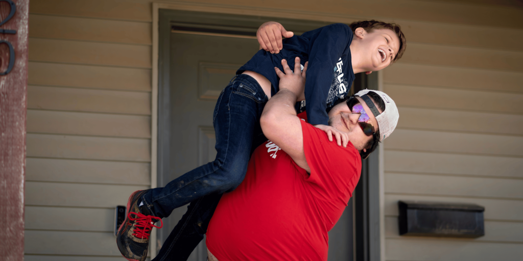 Brothers rough housing together on the front porch