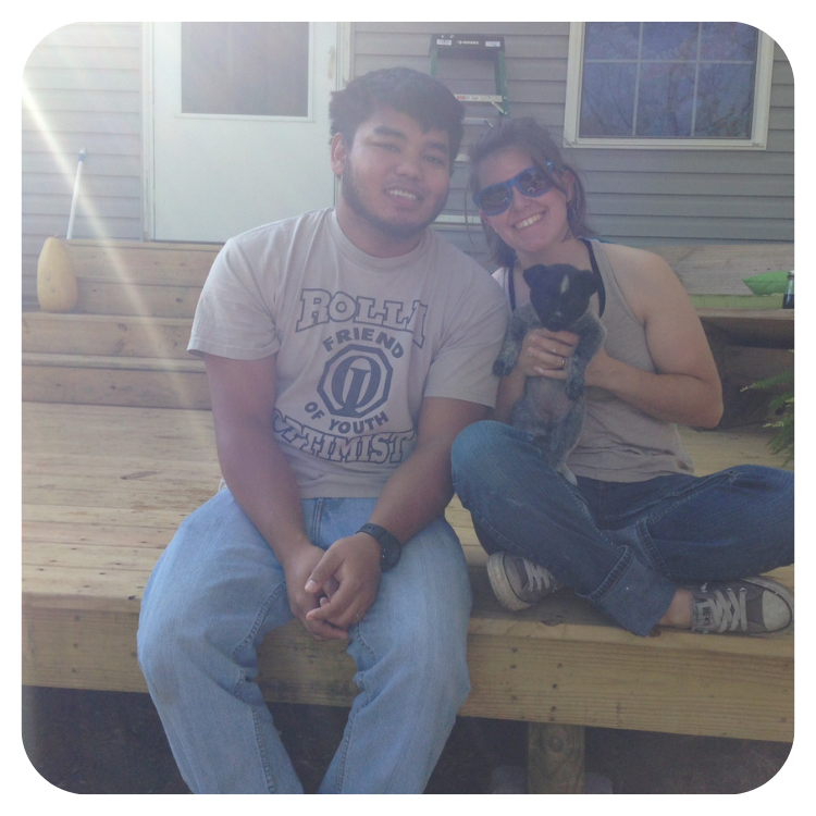 Couple who purchased a home with Springfield Community Land Trust smiling with a puppy in front of their new home